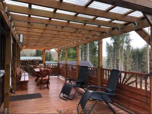 a wooden deck with chairs and a pergola at Luxury villa in Tinjan with private pool in Harzgerode