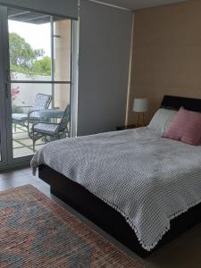 1 dormitorio con 1 cama grande y balcón en Katinka en Augusta
