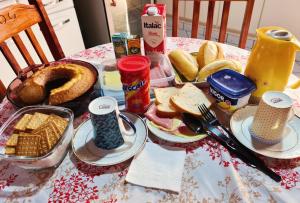 a table with a breakfast of waffles and bread at Pousada Família Capetti in Bauru