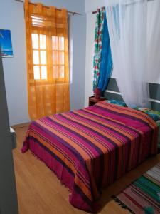 Un dormitorio con una cama con una manta de colores. en Maison LUCIA, en Saint-Pierre