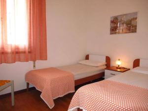 Habitación pequeña con 2 camas y ventana en Apartment in Porto Santa Margherita 42869, en Porto Santa Margherita