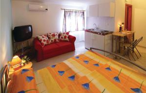 a living room with a red couch and a kitchen at Lovely Apartment In Pula With Kitchen in Pula
