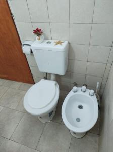 a bathroom with a white toilet and a bidet at Cabaña Céntrica con Balcón Vista a las Sierras in Cosquín
