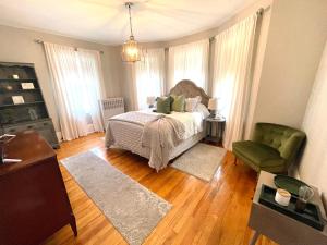 a bedroom with a bed and a green chair at Vida Boutique Inn in Worcester