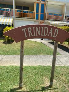 a street sign in the grass in front of a house at Le Mahogany Bleu in Sainte-Anne