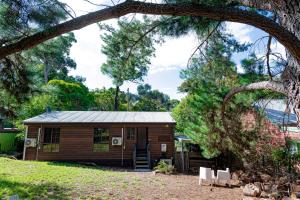 a small cabin in a yard with trees at Hideaway@Hepburn in Hepburn Springs