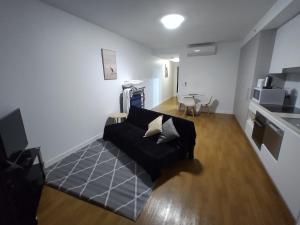 a living room with a black couch and a table at Best View in Port Hedland in Port Hedland