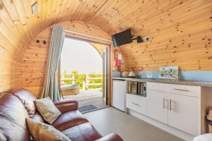 a living room with a couch and a kitchen at Two Hoots in Flint