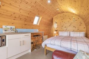a bedroom with a bed in a wooden room at Two Hoots in Flint