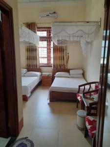 a bedroom with two beds and a window at Khách sạn Vườn Quốc gia Ba Bể in Bak Kan