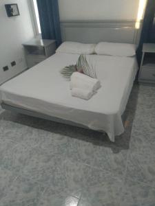 uma cama branca com duas toalhas em cima em RECIDENCIAL MIGNOLI em Boca Chica
