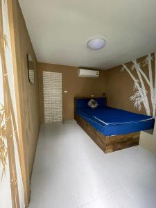 
a bedroom with a blue wall and a blue bed at Phangan Arena Hostel in Ban Tai
