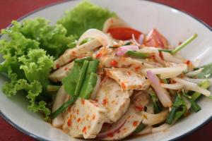 a white plate of food with chicken and vegetables at Hideaway Guest House And Bar in Pattaya
