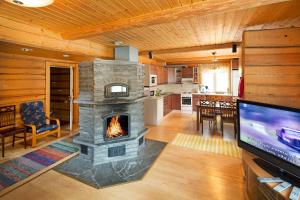 a living room with a stone fireplace in a house at Tervalepikon Torpat in Sysmä