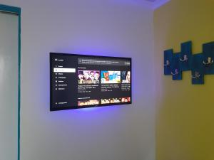 TV de pantalla plana colgada en la pared en The Jazmine's Apartment, en Oranjestad