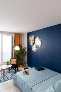 Dormitorio azul con cama y pared azul en Studio Cosy Cahors- proche Gare et Centre-Ville en Cahors