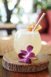 a drink with a purple flower on a wooden table at The Front Hotel and Apartments in Patong Beach