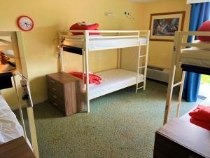 a room with two bunk beds and a clock at Bposhtels Orlando Florida Mall in Orlando