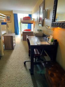 a room with a desk and a bedroom with bunk beds at Bposhtels Orlando Florida Mall in Orlando