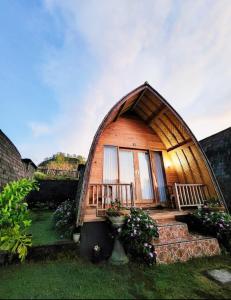 a small house with a large window and a staircase to it at Bali Cottages Lake View in Kintamani