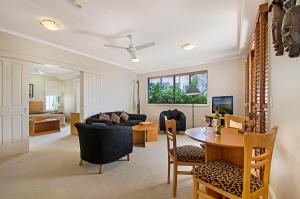 sala de estar con mesa y sofá en Myconos Resort, en Maroochydore