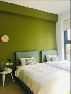una camera da letto con un letto e una parete verde di Yishan Village a Jincheng