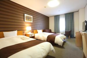 Giường trong phòng chung tại Fukuoka Recent Hotel