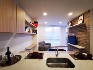 a kitchen with a sink and a living room at Apartamento exclusivo en Manizales-Gran ubicación! in Manizales