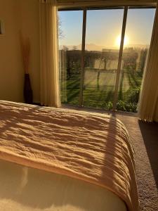 a bedroom with a bed and a window with a view at Walnut Block Cottages in Blenheim