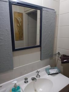 a bathroom with a sink and a mirror at City Stadium 5 minutes Walk in Townsville