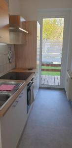 a kitchen with a large glass door to a patio at Möblierte Wohnung auf Zeit in Mühlhausen