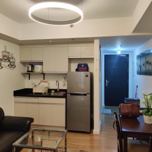 a kitchen and living room with a stainless steel refrigerator at Abreeza Condo T2-2820 in Davao City