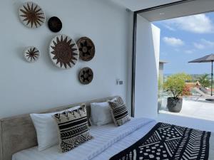 a bedroom with a bed with pillows and a large window at AURA AIR 1, pool & seaview villa, Choengmon 500m in Koh Samui 