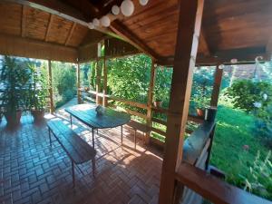 un porche cubierto con mesa y sillas en Casa La Munte - Zona Rucar en Cetatenii