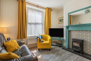 a living room with a couch and a fireplace at Sea Spray in Watchet