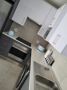 een keuken met witte apparaten bij BellaMare in Port Elizabeth