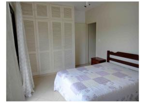 - une chambre avec un lit et un placard blanc dans l'établissement Guarujá, apartamento a 100 metros da praia da enseada., à Guarujá