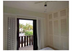 Cette chambre dispose d'un balcon avec une grande fenêtre. dans l'établissement Guarujá, apartamento a 100 metros da praia da enseada., à Guarujá