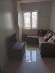 ein Wohnzimmer mit einem Sofa und einem Stuhl in der Unterkunft Family freindly 2 bedroom condo at Vine Residences in Manila
