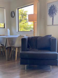 a living room with a blue couch and a table at Sea Renity in Safety Beach +19 photos