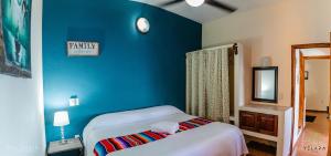 1 dormitorio con cama y pared azul en Casa Vista Magica, en Yelapa