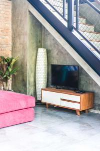 une télévision sur un meuble dans le salon dans l'établissement 3 Bedrooms Tropical Modernism Rice Field and Jungle, à Ubud