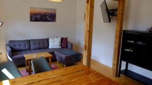 a living room with a couch and a table at "Kutscherstube" - Hammergut Neidberg in Bielatal