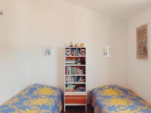 a bedroom with two beds and a book shelf at Villa Marina in Brela