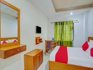 een slaapkamer met een bed en een spiegel bij Marhaba Tourist Home in Kozhikode