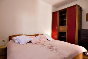 Schlafzimmer mit einem Bett mit rosa und weißen Kissen in der Unterkunft Petar Pan in Šibenik