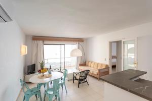 a kitchen and living room with a table and chairs at Apartamentos Lemar in Colonia Sant Jordi