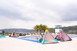 un grupo de niños jugando con cometas en una piscina en Le Charmé Suites - Subic en Olongapo