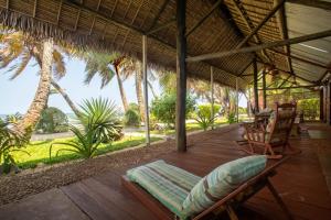 - une terrasse couverte avec un hamac, des chaises et des palmiers dans l'établissement Villas de Vohilava, sur l'île Sainte-Marie
