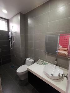 a bathroom with a white toilet and a sink at 米米民宿 in Kluang
